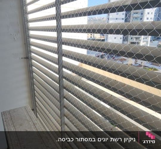 רשת מתכת על חלון למניעת כניסת יונים